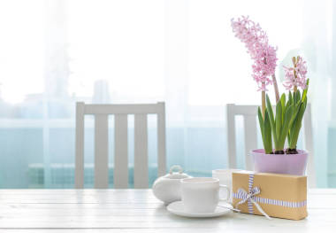 桌上有杯子和花的禮物盒