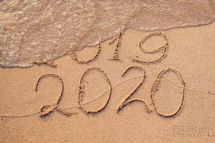 新年2020是未來(lái)概念-題字2019和2020沙灘沙子, 波浪幾乎覆蓋數(shù)字2019