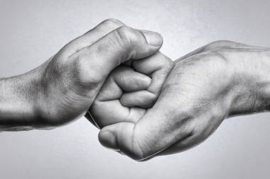 男性和女性的手相互連接。黑白圖像