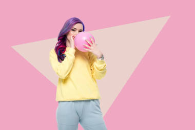 美丽的年轻女子吹气球的创意背景