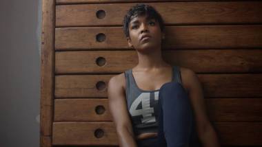 年輕的健身和色調(diào)的女人坐在木制衣柜在健身休息