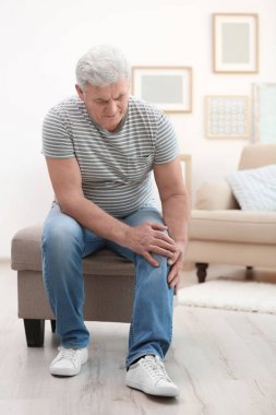 患有膝痛的成年男子在家中图片