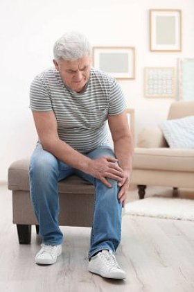 患有膝痛的成年男子在家中图片