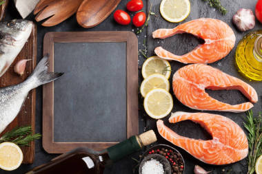 生鮭魚魚片和在切割板上的香料烹調的黃金。具有文本空間的頂部視圖