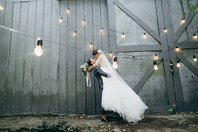 年轻的一对新婚夫妇摆在户外。新郎举行新娘