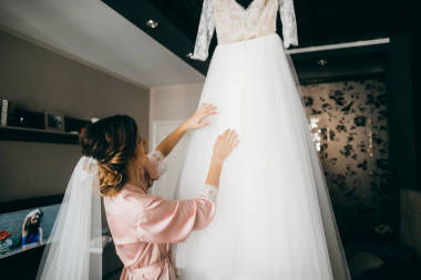 年輕美麗的新娘看她的婚紗禮服