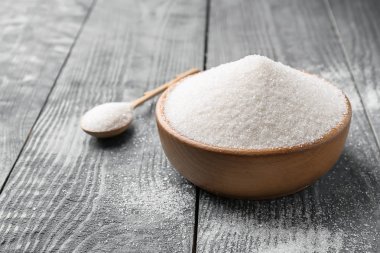 木桌上有纯糖的碗和勺子图片