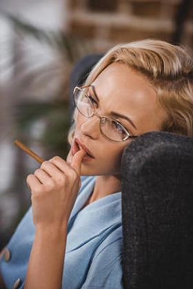 美丽的金发女人戴着香烟, 看着远处, 五十年代的风