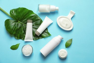 不同的護膚化妝品與綠葉的顏色背景, 頂部視圖