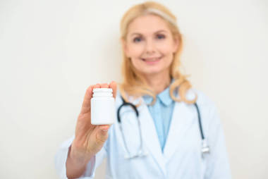 女性醫(yī)生的特寫鏡頭白色的藥丸罐