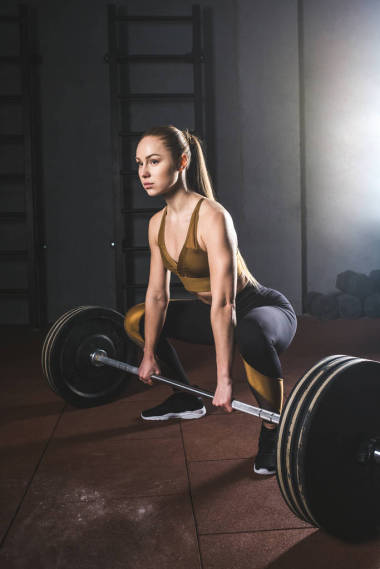 年轻的运动员准备在健身房提高杠铃