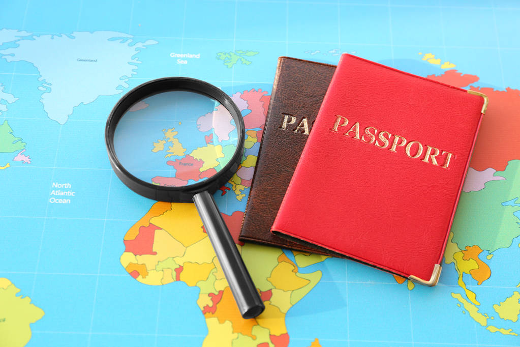 放大镜, 世界地图上的护照。移民概念 放大镜, 世界地图上的护照。移民概念