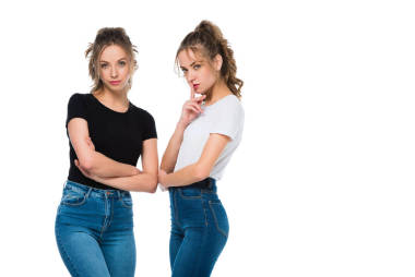 自信迷人的年轻双胞胎看着相机在白色隔离