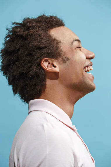 快樂(lè)的商人站在藍(lán)色的背景上微笑