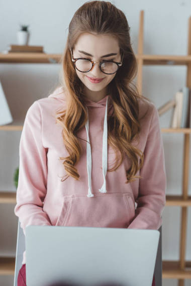 金發(fā)女學生坐和使用筆記本電腦