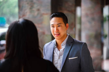 两位专业商务人士的肖像散步和交谈。当他们在亚洲一个城市的街道上行走时, 他们深深地交谈着。男人和女人都穿着专业的衣服