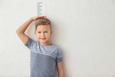 小男孩測(cè)量高度在輕的墻壁附近