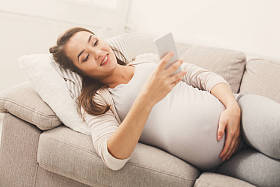 快乐怀孕妇女使用智能手机图片