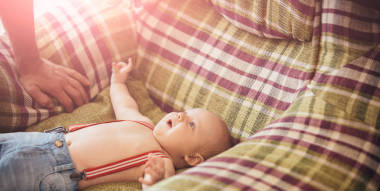 穿著吊帶褲的小男孩躺在扶手椅上