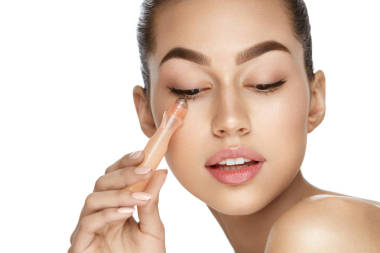 眼部皮肤护理。美丽的女人使用奶油