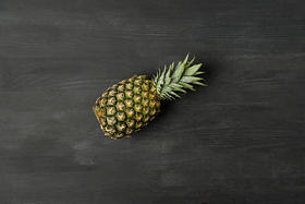 顶视图新鲜成熟的菠萝在黑暗的桌面