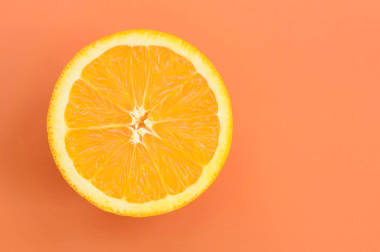 在橙色的背景下, 一个橙色水果片的顶部视图。饱和柑橘纹理图像