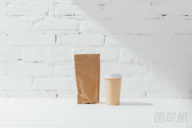 咖啡和一次性杯子的紙包前視圖