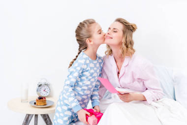 女兒親吻母親和問候與愉快的母親天