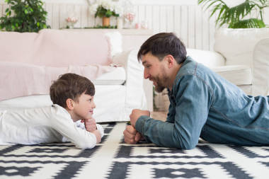 父親應(yīng)該讓你感到安全!側(cè)面查看照片的父親和男孩玩盯著比賽, 而在地板上在家