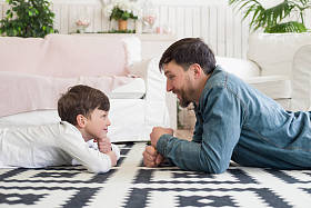 父亲应该让你感到安全!侧面查看照片的父亲和男孩玩盯着比赛, 而在地板上在家