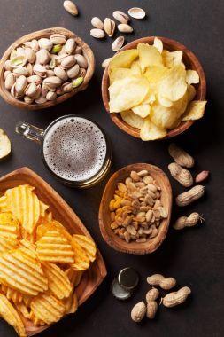 石桌上有啤酒和小吃。堅果薯條頂部視圖