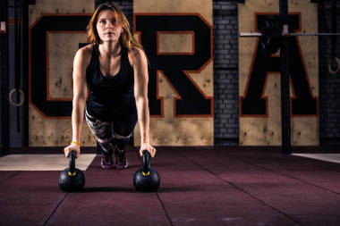 有吸引力的年輕健身房健身婦女做俯臥撐