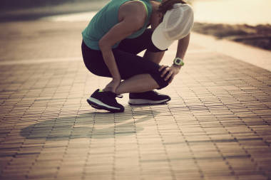 運動腿受傷婦女賽跑者圖片