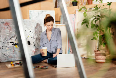 有選擇的焦點, 美麗的年輕藝術(shù)家拿著咖啡去和使用筆記本電腦在工作室