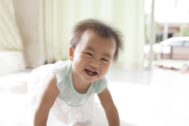 亞洲嬰兒 10 個(gè)月歲爬在客廳里的臉