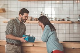 愉快的女孩接受礼物从男朋友