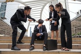 绝望的商人反对笑的工友照片