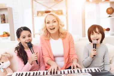 老婦人演奏合成器和教孫輩唱