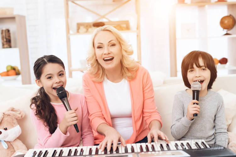 老婦人演奏合成器和教孫輩唱