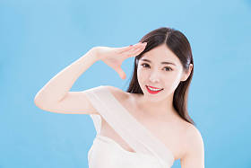 蓝色背景的妇女与太阳保护手势