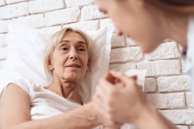 女孩照顧老人在床上的家庭和他們牽手