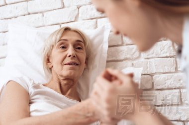 女孩照顧老人在床上的家庭和他們牽手