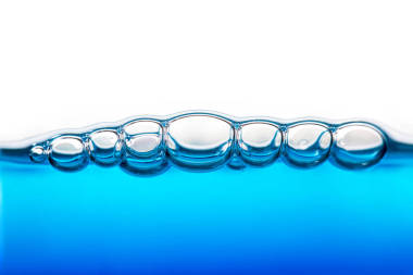 白色背景下清澈蓝水中氧气气泡的近