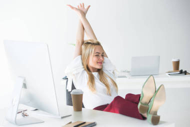 美麗的微笑年輕的女商人, 閉著眼睛在工作場(chǎng)所伸展