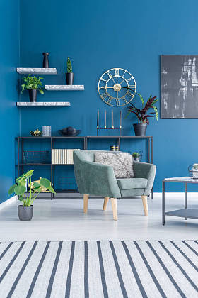 彩色起居室内带绿色扶手椅的条纹地毯与海军蓝墙