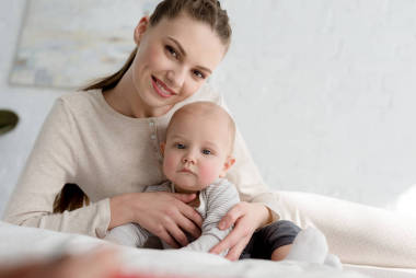 微笑的妈咪与小儿子在床上图片