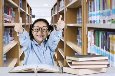 可愛的女生在圖書館里豎起大拇指