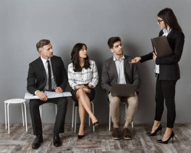 女實業(yè)家選擇工作面試的同事坐在灰色墻上