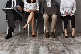 有数字设备和文件夹的商务人员的部分视图等待工作面试