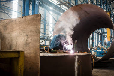 工廠內(nèi)部的藍(lán)領(lǐng)工人焊接照片